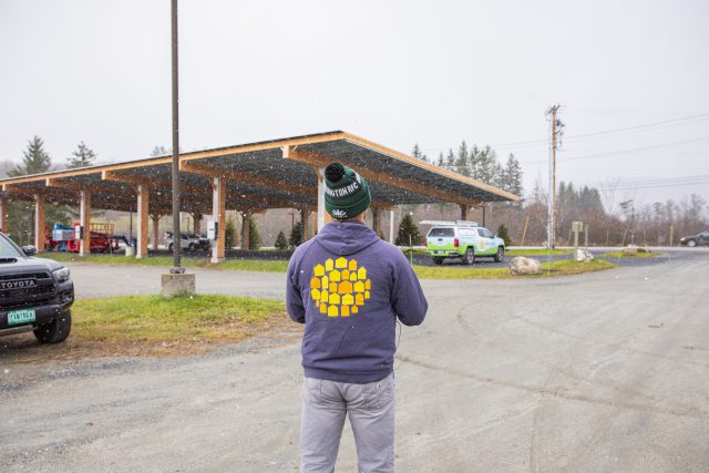 suncommon employee in front of lawson's finest solar canopy